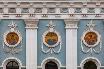 A fragment of the wall of an Orthodox church with round icons and a stucco pattern