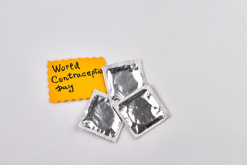 World contraception day concept. Three packs of condoms. Isolated on grey background.