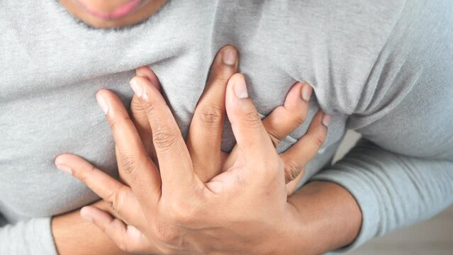 young man suffering pain in heart and holding chest with hand 