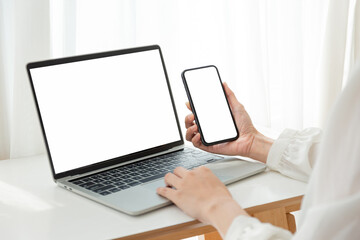 computer screen,cell phone blank mockup.hand woman work using laptop texting mobile.white...