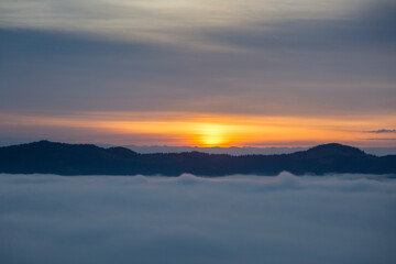 Foggy clouds fell below mountain level at sunrise