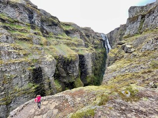 Woman looking at Glymur waterfall, second highest waterfall of Iceland.