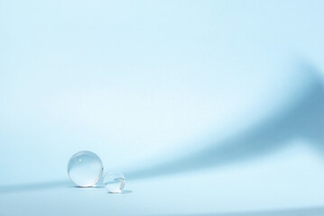 Blue background with transparent glass balls. Minimal concept and hard sunlight.