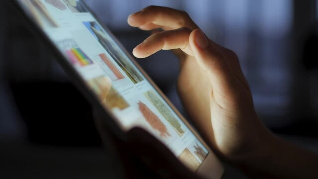 Close up shot of hand fingers scrolling through the social internet browser feed on tablet computer.