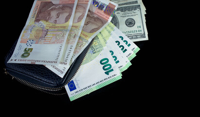 one hundred American dollars and one hundred euros a lot from a black wallet, the Bulgarian lev lies on top of the wallet on a black background
