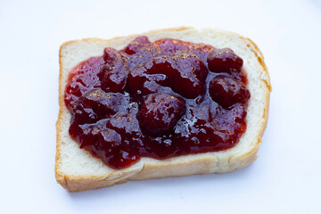 Bread with strawberry jam on white background