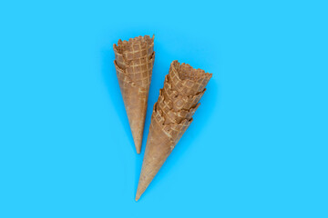 Empty ice cream cone on blue background.