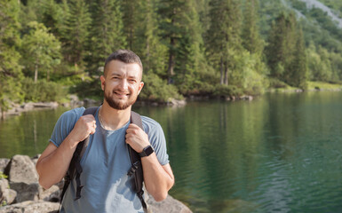 portrait of hiker man in front of lake in mountains, zakopane, morkie oko.