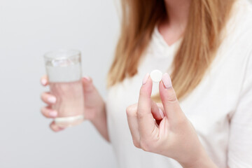 Naklejka premium a tablet in hand and a glass of water. close-up