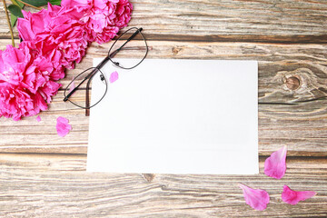 Obraz premium glasses with peonies and layout on a wooden background