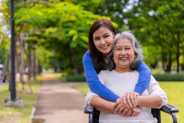 Asian careful caregiver or nurse taking care of the patient in a wheelchair.  Concept of happy retirement with care from a caregiver and Savings and senior health insurance, a Happy family