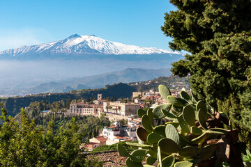 Panoramic view of snow capped Mount Etna volcano on a sunny day seen from Taormina, Sicily, Italy,...