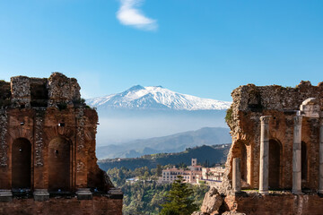 Panoramic view of snow capped Mount Etna volcano on a sunny day seen from the ancient Greek theater...