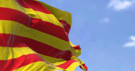 Catalan flag waving in the wind on a clear day - obrazy, fototapety, plakaty