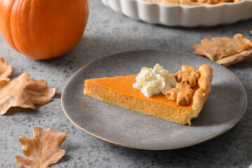 Slice of American Pumpkin Pie for autumn holiday on gray background. Close up. Happy Thanksgiving Day.