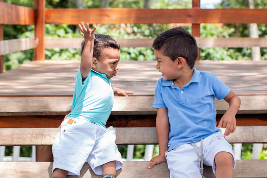 Two Little Boys Playing, Arguing And Laughing. Little Brothers Dressed In Matching Colors.