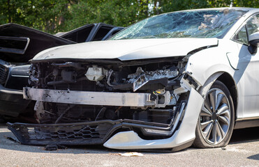 Many broken cars after a traffic accident in the parking lot of a restoration service station on the street. Car body damage workshop outdoors. Sale of insurance emergency vehicles at auction.