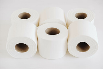 Rolls of white toilet paper on a white background