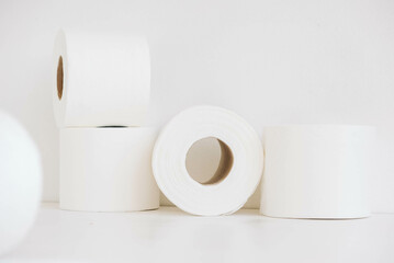 Rolls of white toilet paper on a white background