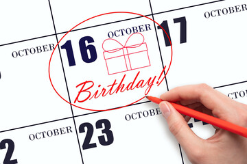 The hand circles the date on the calendar 16 October, draws a gift box and writes the text Birthday. Holiday.