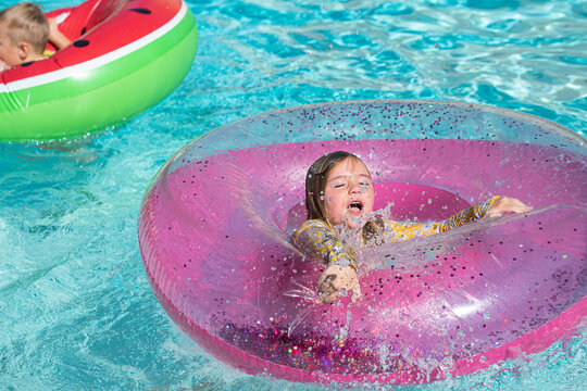 Girl Jumps Through Hole In Tube In A Swimming Pool