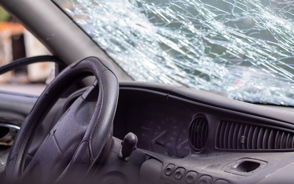 Close-up Of The Steering Wheel Of A Car After An Accident. The Driver's Airbags Did Not Deploy. Soft Focus. Broken Windshield With Steering Wheel. Vehicle Interior. Black Dashboard And Steering Wheel.