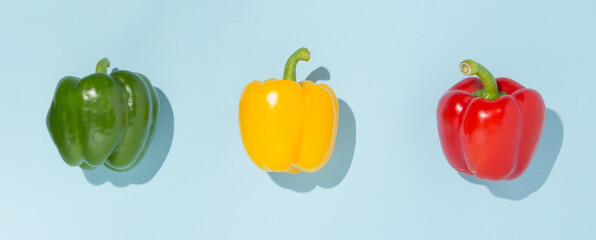 Green, yellow and red pepper on pastel background. Vegetable minimal concept.