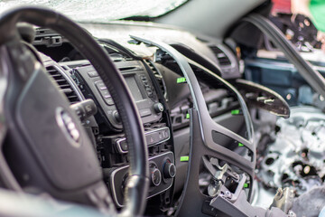 Close-up of the steering wheel of a car after an accident. The driver's airbags did not deploy. Soft focus. Broken windshield with steering wheel. Vehicle interior. Black dashboard and steering wheel.