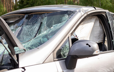 Close-up of a car with a broken windshield after a fatal crash. Consequence of a fatal car accident. Automobile danger. Reckless dangerous driving. Vehicle after an accident with a pedestrian.