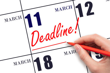 Hand drawing red line and writing the text Deadline on calendar date March 11. Deadline word written on calendar
