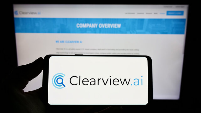 Stuttgart, Germany - 05-26-2022: Person holding smartphone with logo of facial recognition company Clearview AI Inc. on screen in front of website. Focus on phone display.
