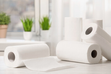 Rolls of paper towels on white wooden table indoors