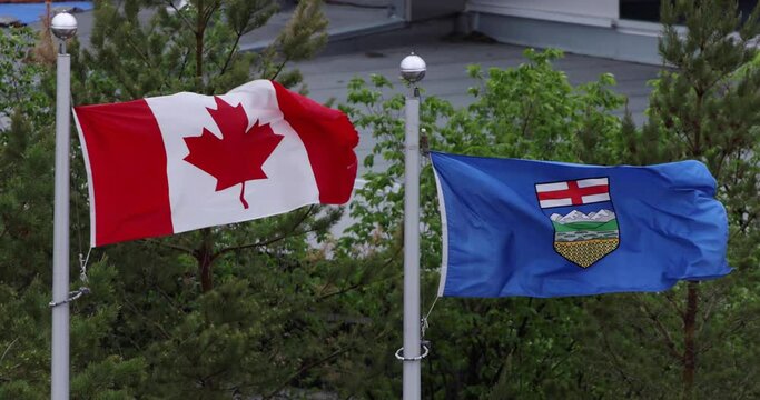 A waving flag of Canada and Alberta on a windy day.