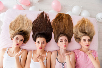 High angle top view photo of sweet dreamy young ladies nightwear lying bed sending kiss indoors...