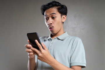 Stunned young emotional man posing against the brown wall