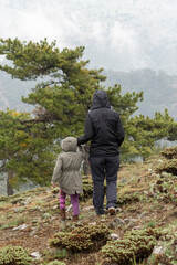 Image of woman and child walking on mountain in nature.