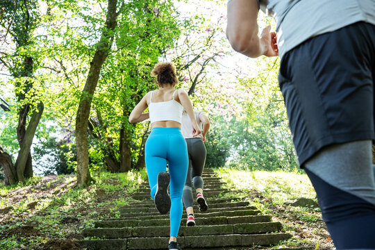 A Group Of People Exercise And Run At The Park.They Were Running Up The Stairs.	