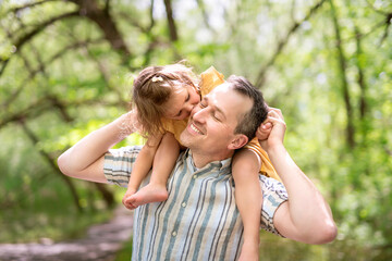 Father with his daughter having fun outside in forest