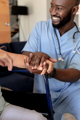 African american male health worker supporting caucasian senior woman sitting on the wheelchair