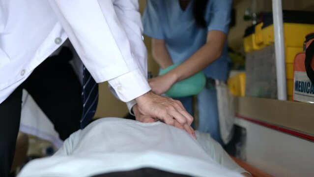 First aid assistance of the ambulance medical team with CPR method and hand-squeezed breathing apparatus