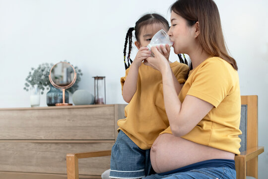 Asian Little Girl Takes Care Of Her Pregnant Mother By Feeding Her Milk, Milk Helps Her Younger Sisters Stay Strong In The Mother's Womb