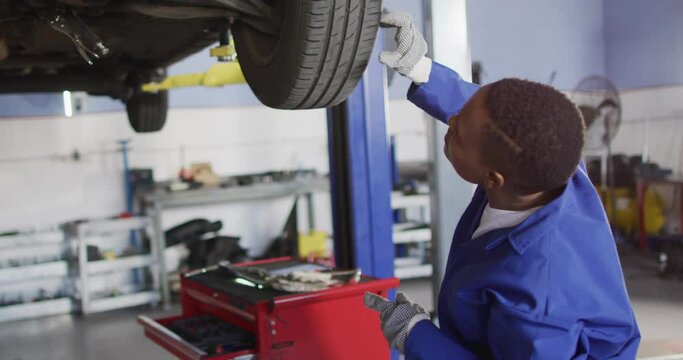 Video of african american female car mechanic changing wheel