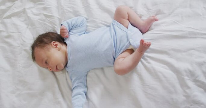 Video of caucasian newborn baby lying on bed