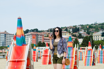 Fototapeta na wymiar Beautiful happy woman walking, relaxing, drinking coffee, enjoying in sunny day at beach. Summer. Drinking coffee. Adriatic Sea.