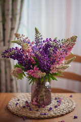 Still-life. A bouquet of bright lupines in a vase.