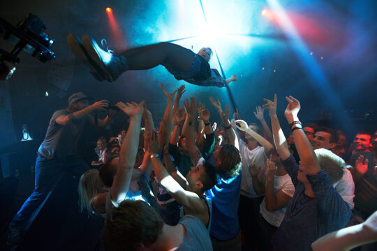 Falling into the crowd. A band playing on stage at a concert- This concert was created for the sole purpose of this photo shoot, featuring 300 models and 3 live bands. All people in this shoot are