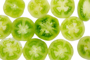 Fototapeta na wymiar green unripe tomatoes slices isolated on white background