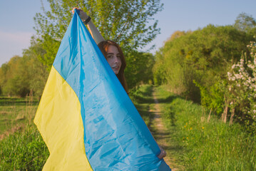 portrait of a young woman wrapped in the Ukrainian flag
