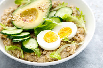 Oatmeal porridge with boiled egg, cucumber and avocado