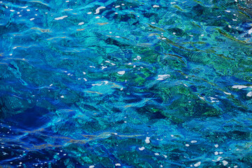 Blue and teal colors of a close-up of the crystal clear waters of the Tyrrhenian sea, on the coast of Capri island, Italy